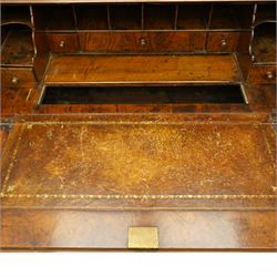 Queen Anne burr walnut chest on stand, moulded projecting cornice over arched mirror glazed doors, above a sloping fall front enclosing fitted interior with pigeonholes and correspondence drawers, fitted with foliate brass escutcheons, shaped apron over tapered baluster turned supports united by curved stretchers, early 18th century with later restorations 