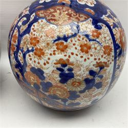 Pair of large 19th century Japanese Imari porcelain bottle vases, painted with shaped reserves of peonies, chrysanthemums and prunus blossom, each H46cm