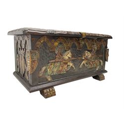 Carved wooden blanket chest, the tooled hinged lid with shaped metal strap hinges and catch, the front carved with arcade over two medieval jousters, on carved sledge feet