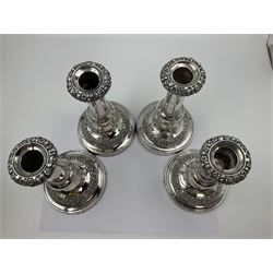Four George III silver candlesticks, each upon knopped stem and weighted circular stepped foot, the foot and removable sconce repousse decorated with a band of flower heads, hallmarked to sconce and foot Thomas & John Settle, Sheffield 1820, H17.5cm