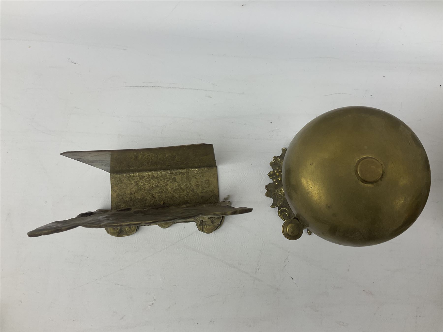 Collection of victorian and later brass desk accessories, to include a letter holder with cherub design, ink well of square form with hinged lid, brass table bell, brass casket with relief decoration, etc  