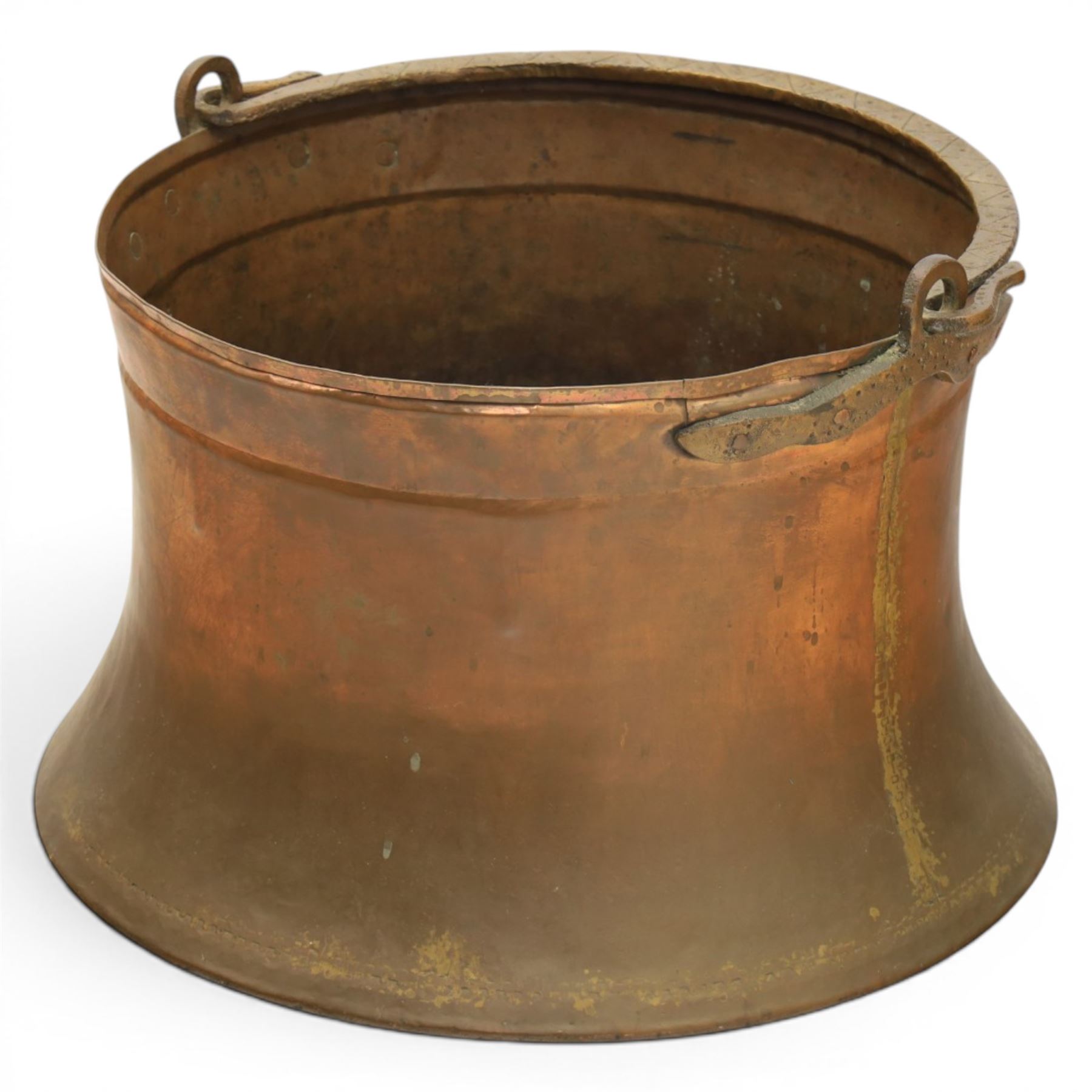 19th century brass and copper cauldron, circular open body with rolled rim, riveted side mounts and swing carrying handle, on broad flared circular foot
