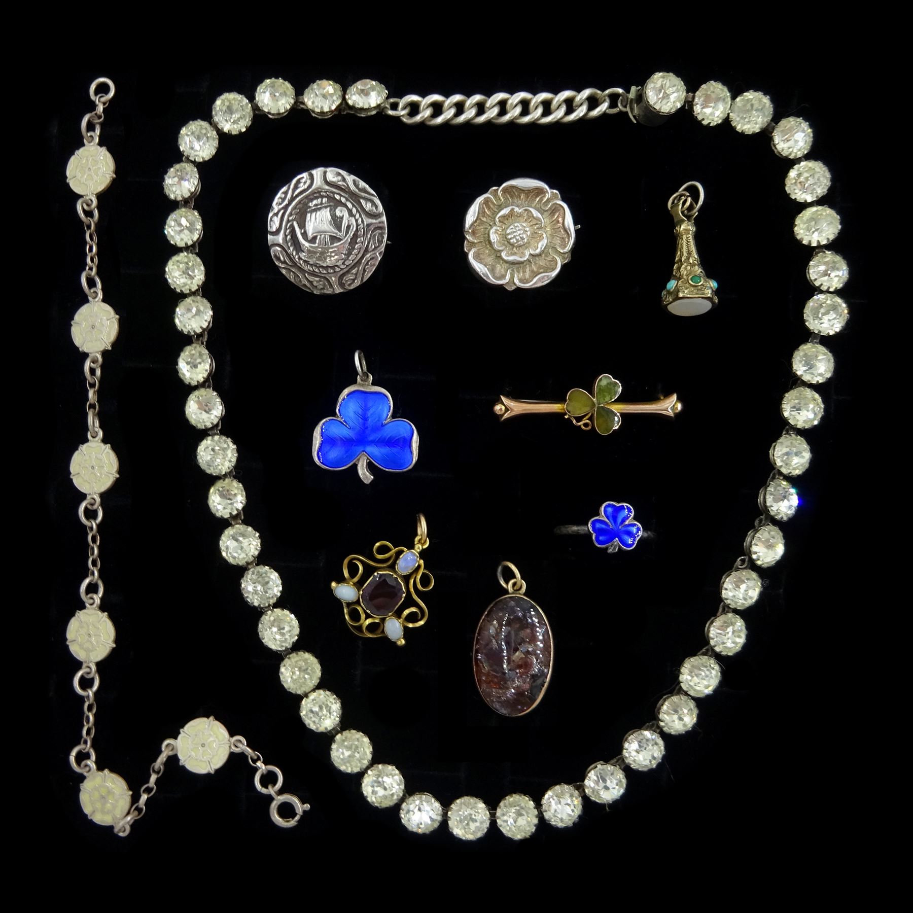 Early 20th century gold agate shamrock brooch, stamped 9ct, gold garnet pendant, silver jewellery including blue enamel shamrock pendant and similar ring, Tudor rose brooch and similar enamelled bracelet, paste stone riviere necklace and a Viking ship brooch, gold mounted glass pedant and a turquoise and agate fob