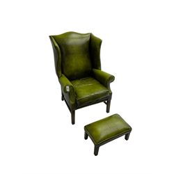 George III design wingback armchair, upholstered in buttoned green leatherette with studwork, raised on square tapering supports, and matching footstool