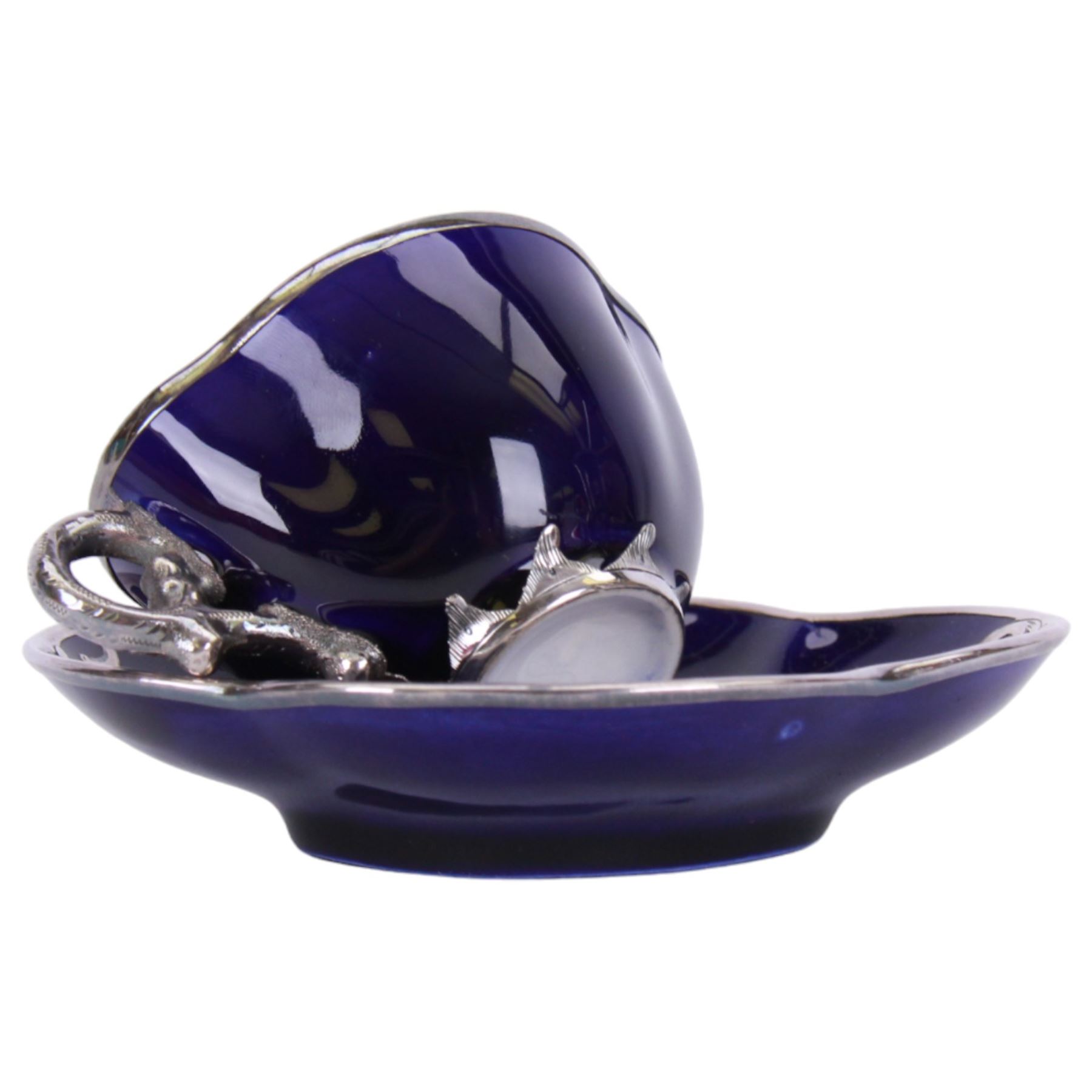 Cranberry glass scent bottle with silver overlay, together with German fluted vase with silver overlay upon a blue ground and similar teacup