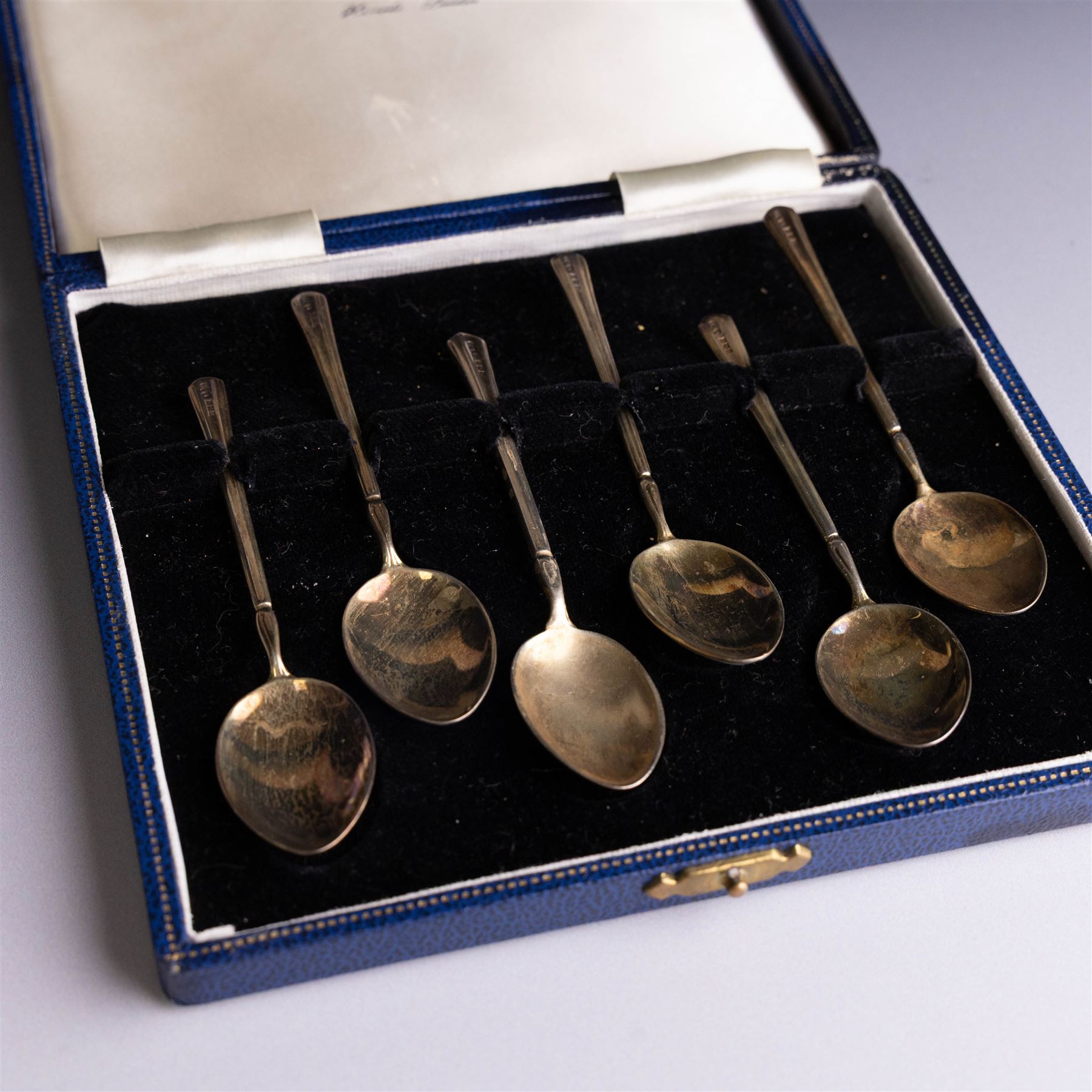 Set of six mid 20th century silver-gilt and guilloche enamel coffee spoons, the undersides of the bowls painted with colourful floral decoration, hallmarked Turner & Simpson Ltd, Birmingham 1960, within Harrods case