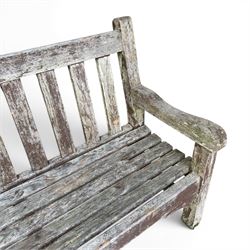 Teak garden bench with slatted back and seat on square supports in weathered which finish 