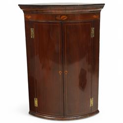 George III inlaid mahogany cylinder corner cupboard, projecting moulded cornice over figured frieze inlaid with shell motifs, two doors with checkered stringing enclosing three shelves, circa 1800