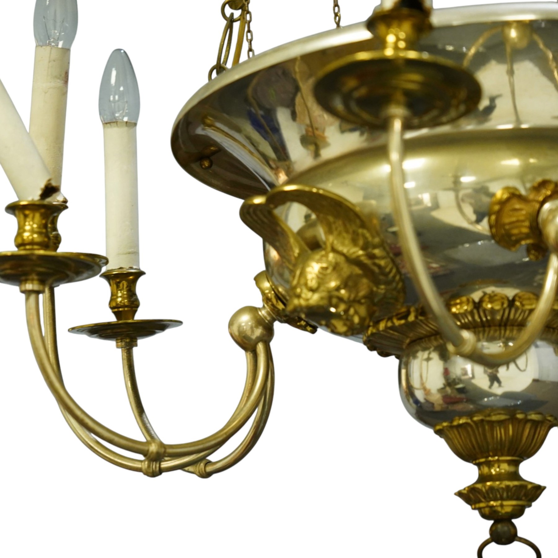 Regency Revival chromium-plated and gilt-brass nine-light chandelier of Neoclassical design, the dished central bowl applied with substantial gilt winged cherub-mask mounts and issuing nine scrolling branches with circular drip pans and faux candle sleeves, over a spherical terminal with gilt-metal gadrooned flower-petal collar and ring, max. diameter 75cm