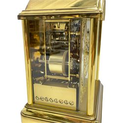 A 20th century brass cased Kieninger (German) chiming mantle clock with a break arch top and three glazed panels, polished sheet brass dial with applied  brass fretwork and a silvered chapter ring, Roman numerals, minute track, steel serpentine hands and seconds dial, three-train spring driven 8-day movement with Westminster, St Michael and Whittington chimes on 8 gong rods, 9 jewel lever platform escapement.  With key. 