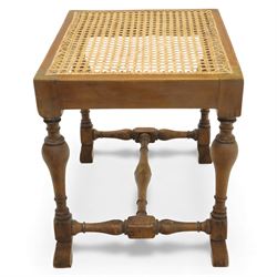 Two upholstered and caned footstools, a late Victorian carved mahogany footstool, oval form upholstered in geometric kilim-style fabric, on cabriole supports (H 27cm, W 56cm, D 47cm), together with a 20th century beech stool, square caned seat on turned supports united by stretchers (H 43cm, W 44cm, D 37cm)