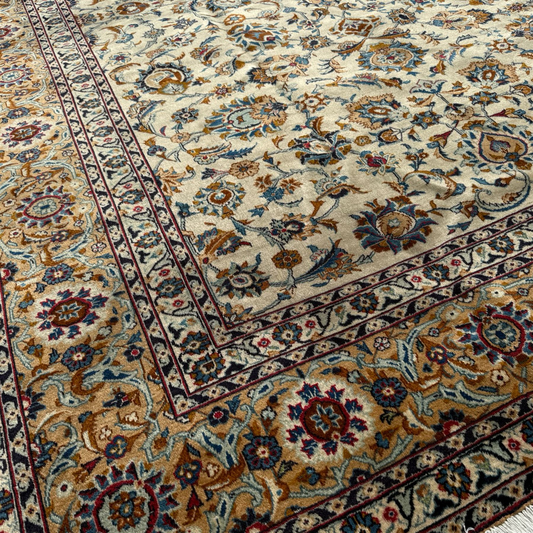 Kashan Persian rug, hand knotted, ivory ground rug, the rosette medallion decorated with projecting palmettes, on a field of swirling leafy branches and decorated with further palmettes, the scrolling border with repeating stylised plant motifs, within floral pattern guard stripes