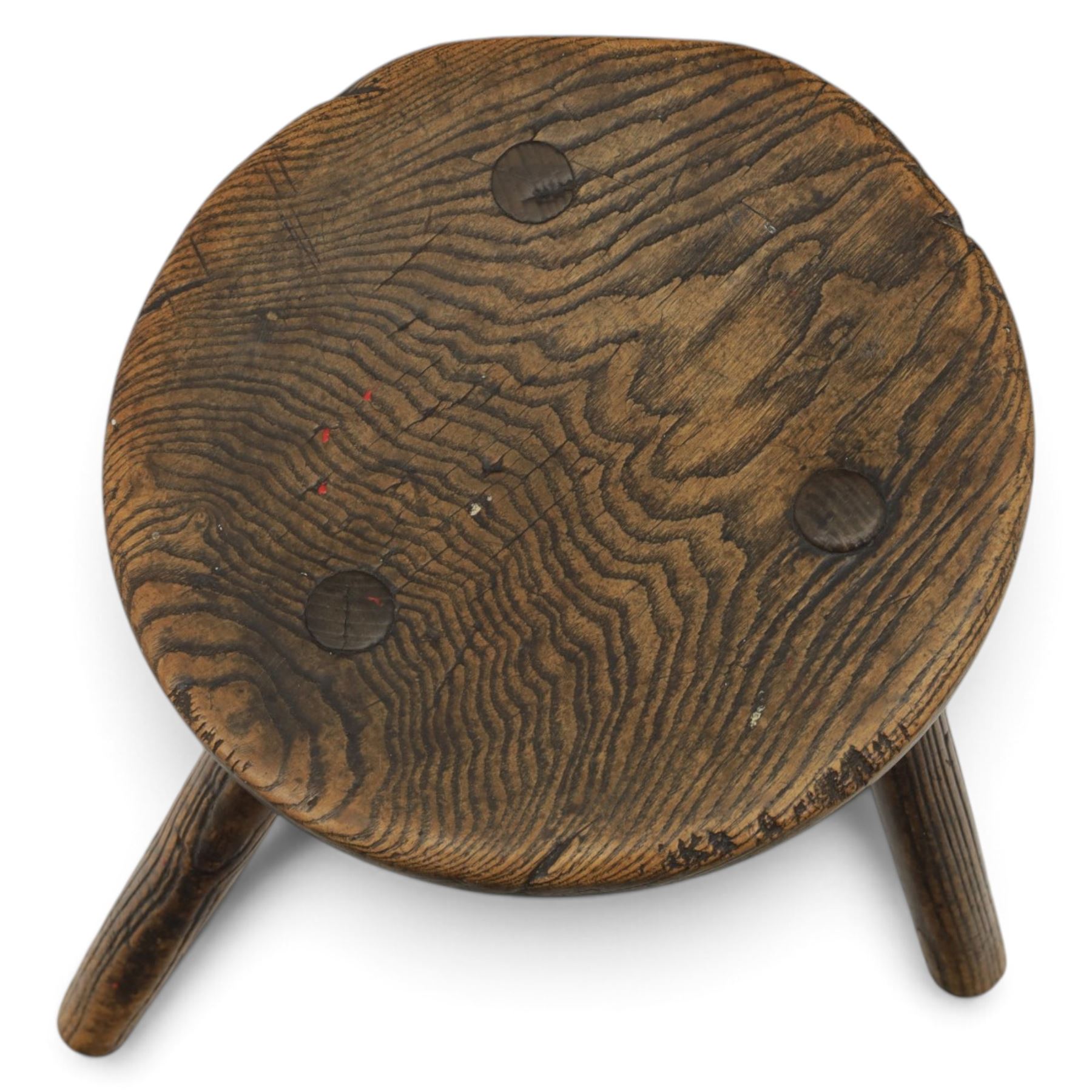 18th century ash and elm milking stool, circular figured top raised on cylindrical supports