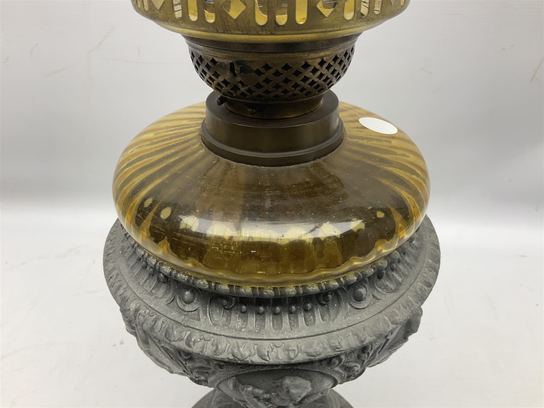 Victorian cast spelter oil lamp, decorated with cherubs and foliate scrolls, supporting a glass reservoir, burner and clear glass chimney, H62cm