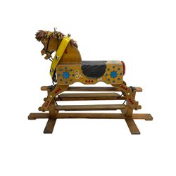 Painted rocking horse on polished pine trestle base