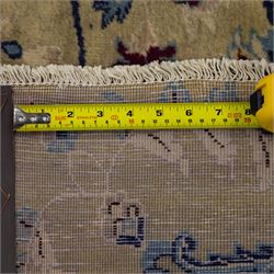 Central Persian Kashan hand-knotted carpet, ivory field with central shaped medallion, surrounded by intricate arrangement of scrolling vine and floral motifs in  pale blue tones, within conforming spandrels and matching border, cotton fringe ends  