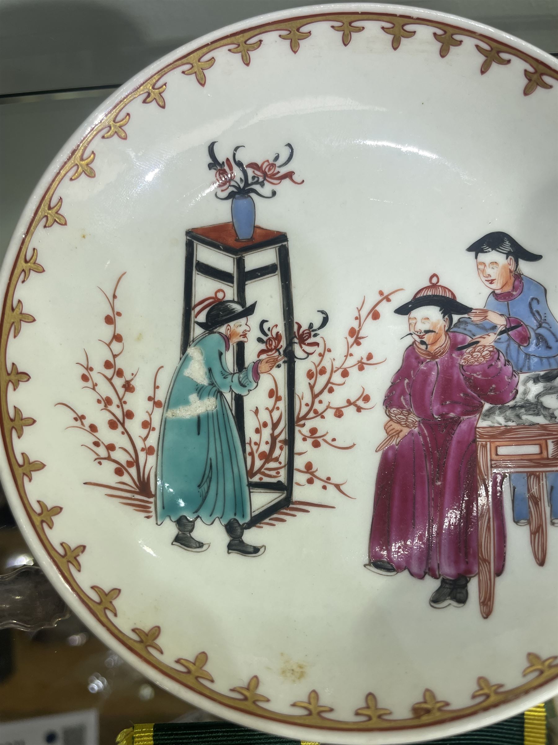 18th century Worcester trio, comprising coffee cup, small bowl and saucer, decorated with a Chinese scene of a flower seller in polychrome enamels, within gilt spearhead borders, saucer D12cm (3)