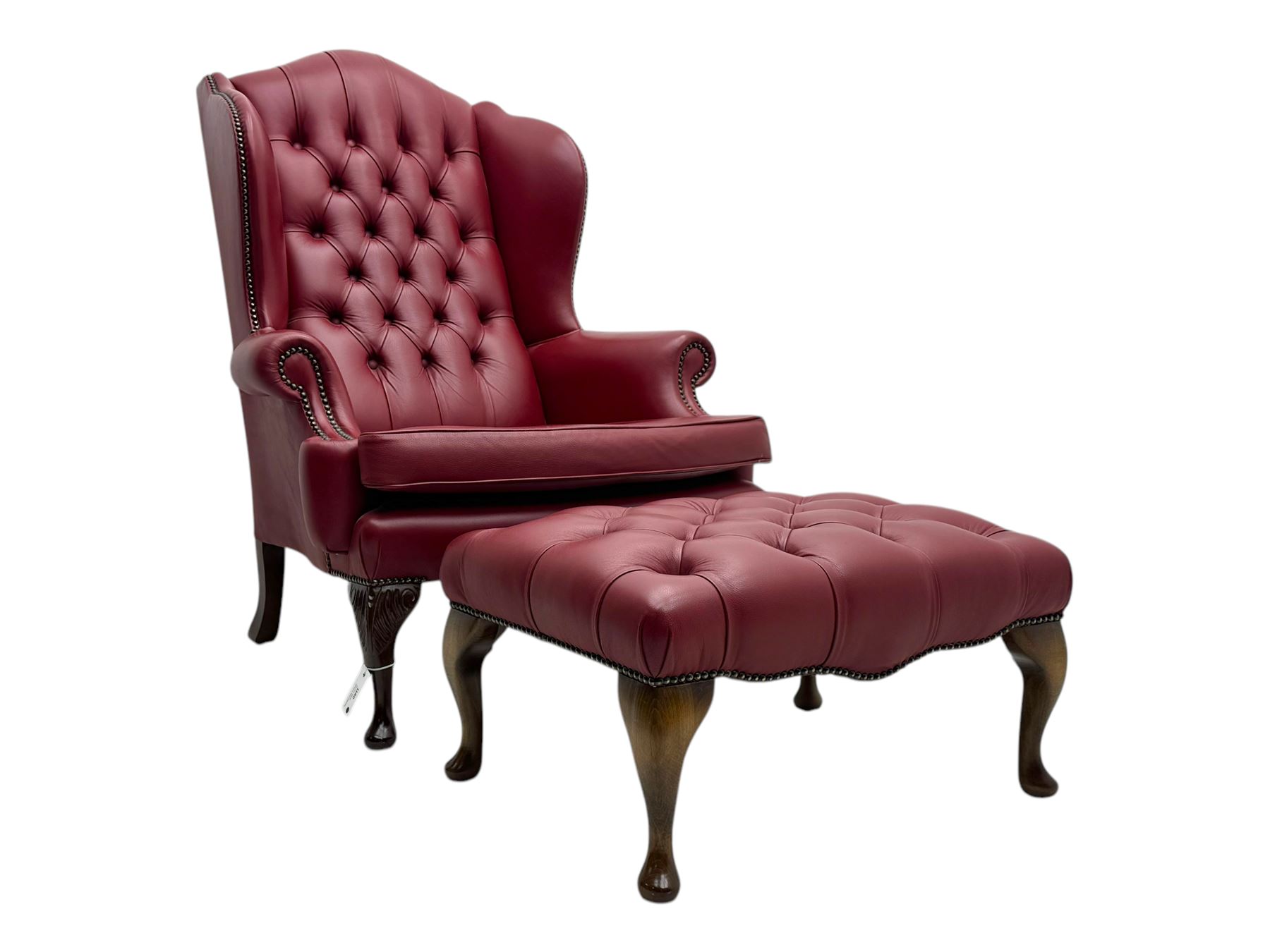 Kingsgate - contemporary 'Queen Anne' wingback armchair with matching stool, high back with deep button tufting, upholstered in red leather with brass stud trim, on carved cabriole supports