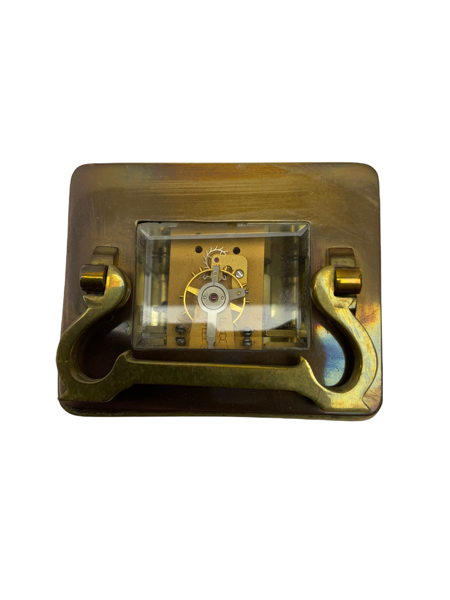 An early 20th century French timepiece carriage clock in a Corniche case with a white enamel dial , Roman numerals, decorative steel hands and minute markers, four bevelled glass panels and a rectangular panel to the top, with a replacement jewelled lever platform escapement with timing screws.