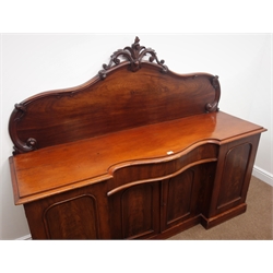  Victorian mahogany chiffonier, arched back with floral carved cresting, serpentine front central drawer, four cupboards, plinth base, W182cm, H153cm, D50cm  