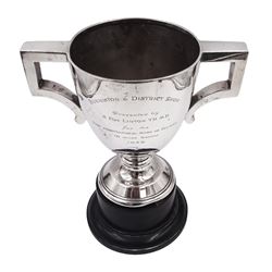1920s silver trophy cup, with angular twin handles, upon knopped stem with circular spreading foot, the body with presentation engraving 'Burniston & District Show, presented by S Fox Linton TD MD, for the Best Agricultural Mare or Gelding, 10 miles radius, 1928' and engraved with winners verso, hallmarked Charles Boyton & Son 1921, upon black plastic base, including base 25cm