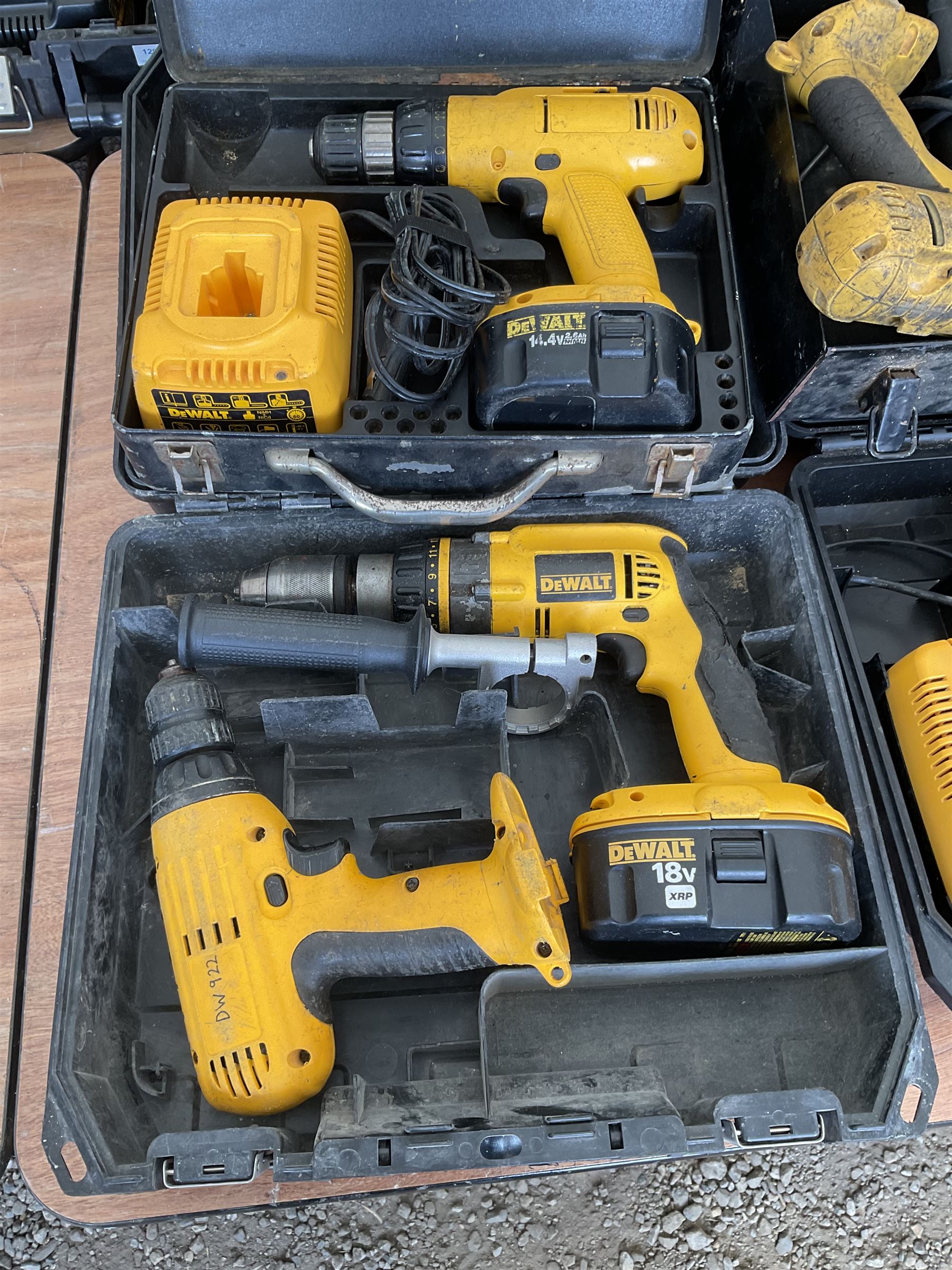 Five DeWalt battery drills with batteries and charger and black and