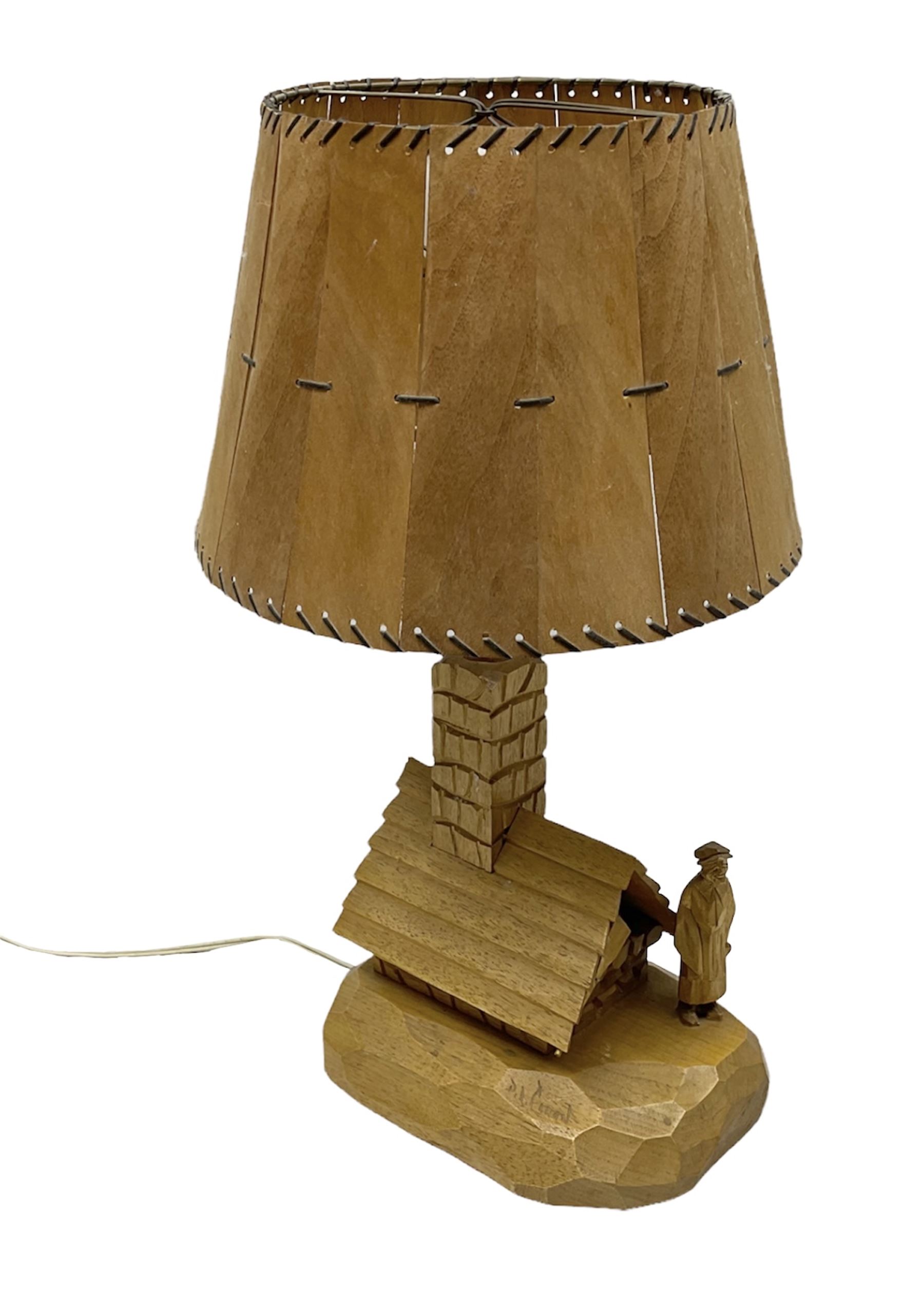 Mid 20th century Paul Caron carved table lamp, modelled as man standing before an oven, the chimney supporting the panelled shade, the base signed P.E. Caron, H42cm