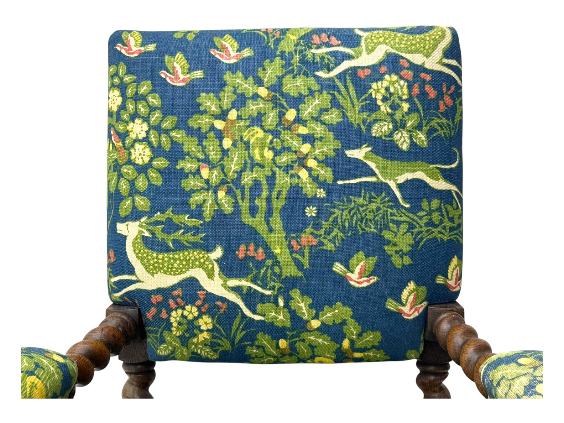 19th century Carolean design oak armchair, upholstered in a vibrant fabric depicting woodland and wildlife scenes, carved lion mask arm terminals, raised on barley twist supports united by H-stretcher