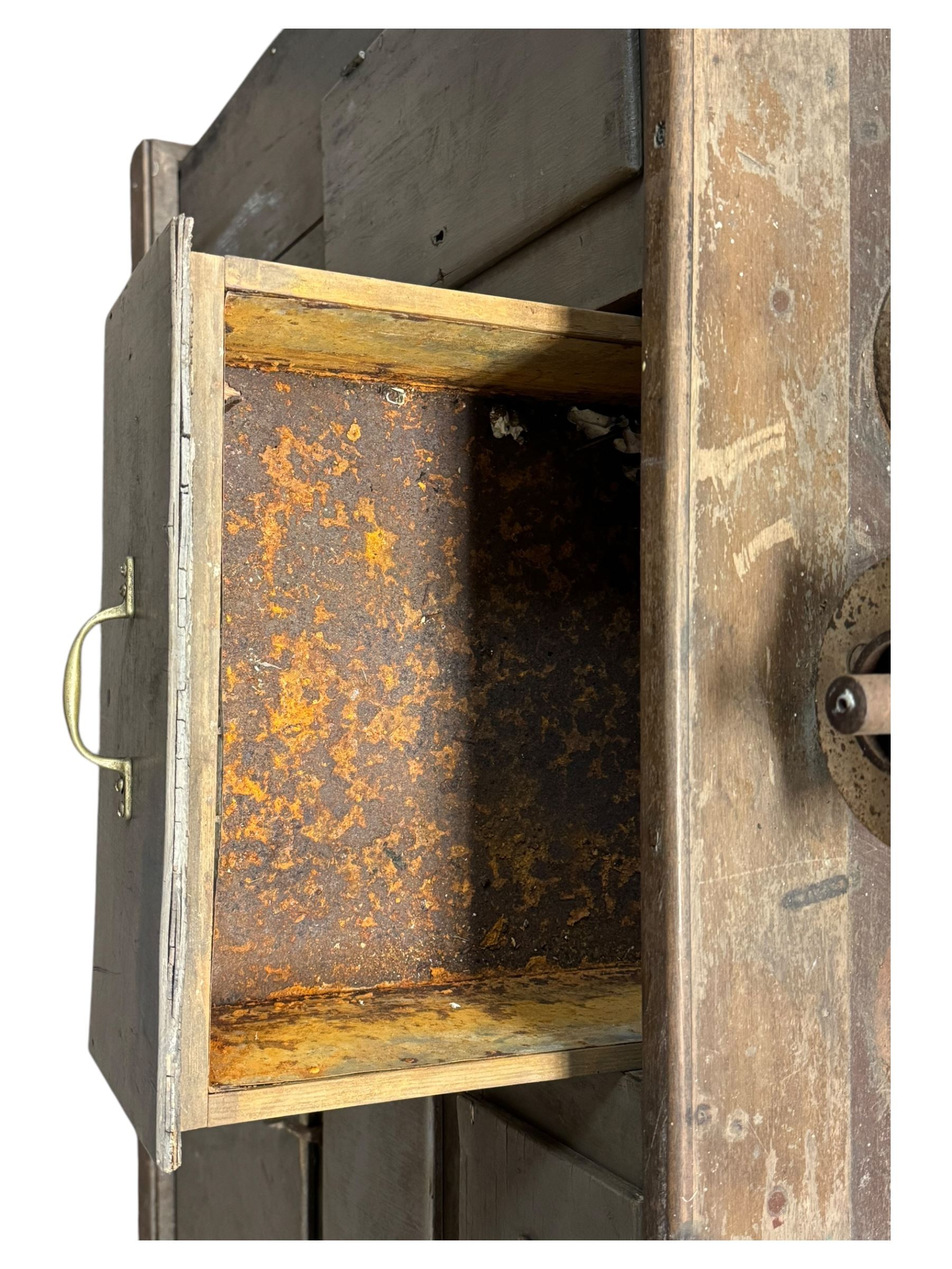 Cabinet with multiple drawers and cupboards mounted with two industrial coffee grinders with large flywheels and brass coffee reservoirs, early 20th century 