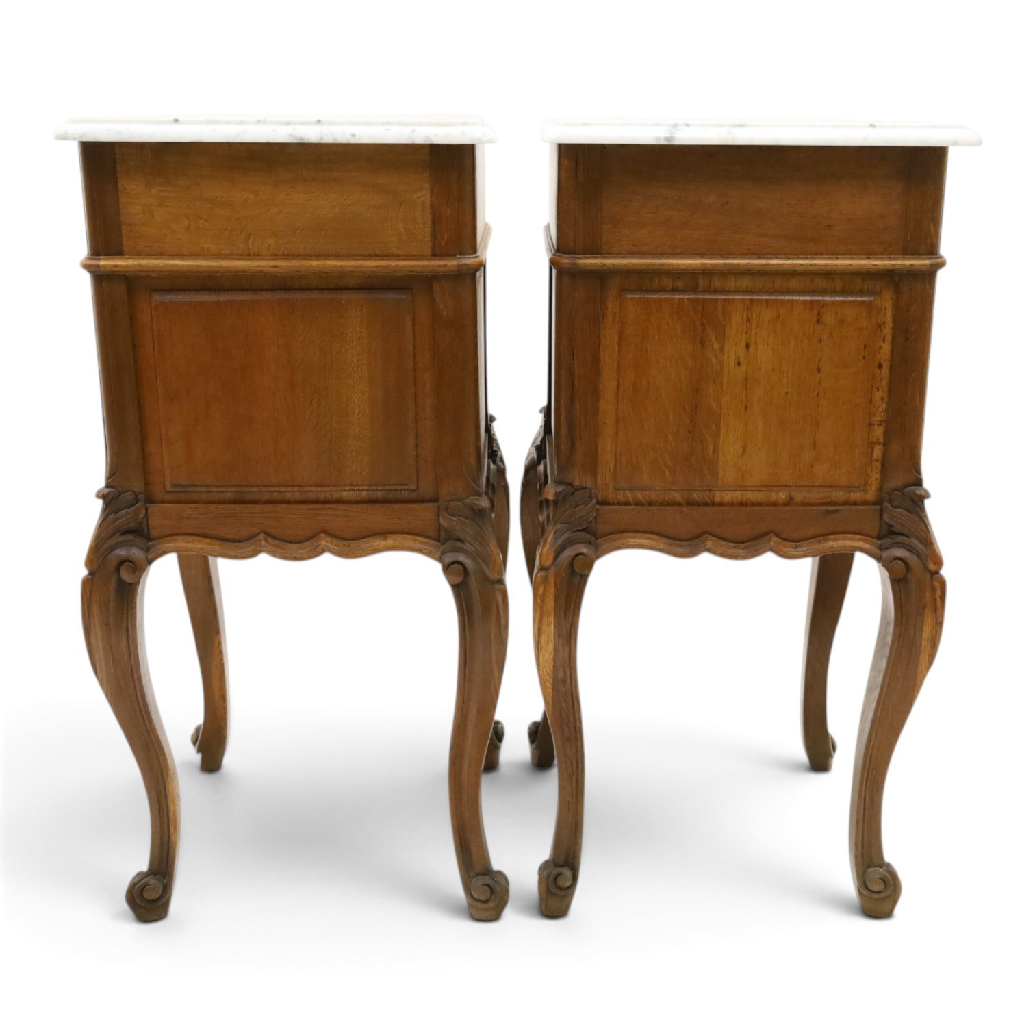 Pair of 20th century French honey oak and marble bedside cabinets, the square marble top with moulded edge, fitted with single drawer over panelled cupboard, shaped and moulded apron over scrolling acanthus leaf applied knees terminating to cabriole legs with scroll feet