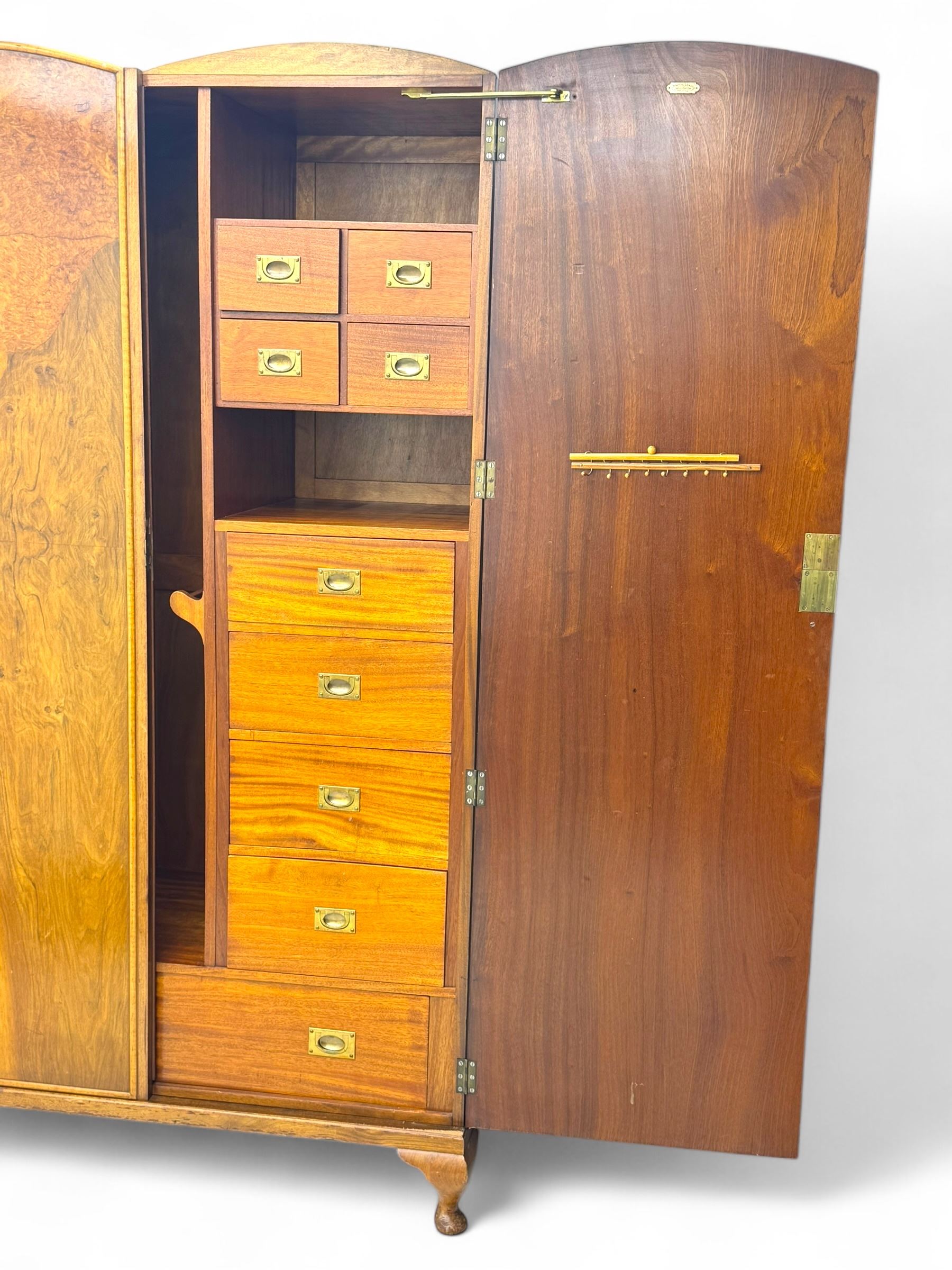 Ashton Leach & Cumberbirch Ltd., Rochdale - early 20th century walnut and mahogany gentleman's wardrobe, arched moulded top with book-matched figured walnut veneers, double doors enclosing fitted interior with hanging rail, tie rack and drawers, raised on cabriole supports