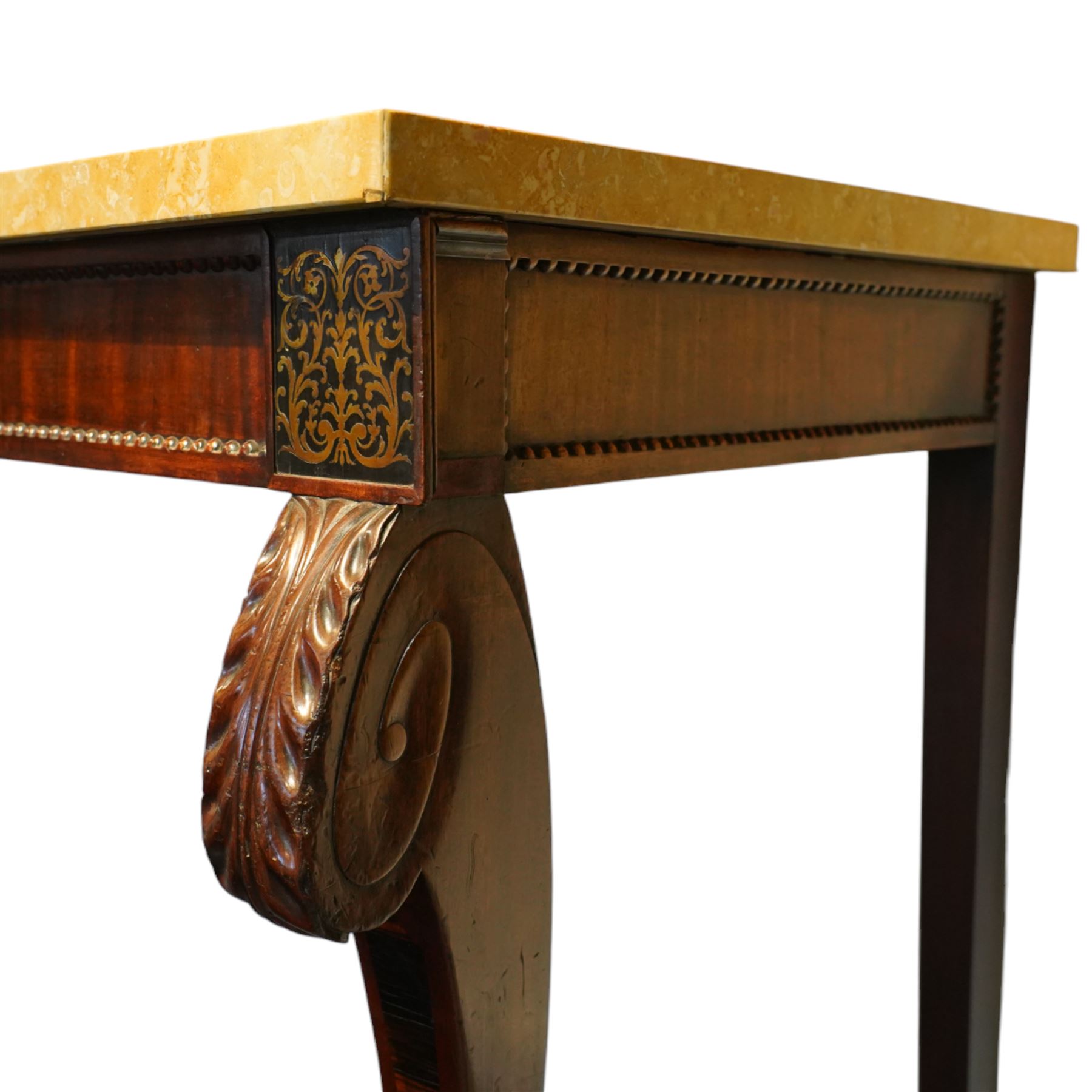 William IV mahogany and brass-inlaid marble serving table, the rectangular marble top featuring yellow tones, bordered by inlaid coloured marble bands in red and black, the frieze with brass-inlaid Boulle-inspired foliate panels on ebony, lower edge with beaded moulding, front legs inlaid with a stripped band of coromandel above carved acanthus leaves, tapering to carved lion paw feet, circa 1830