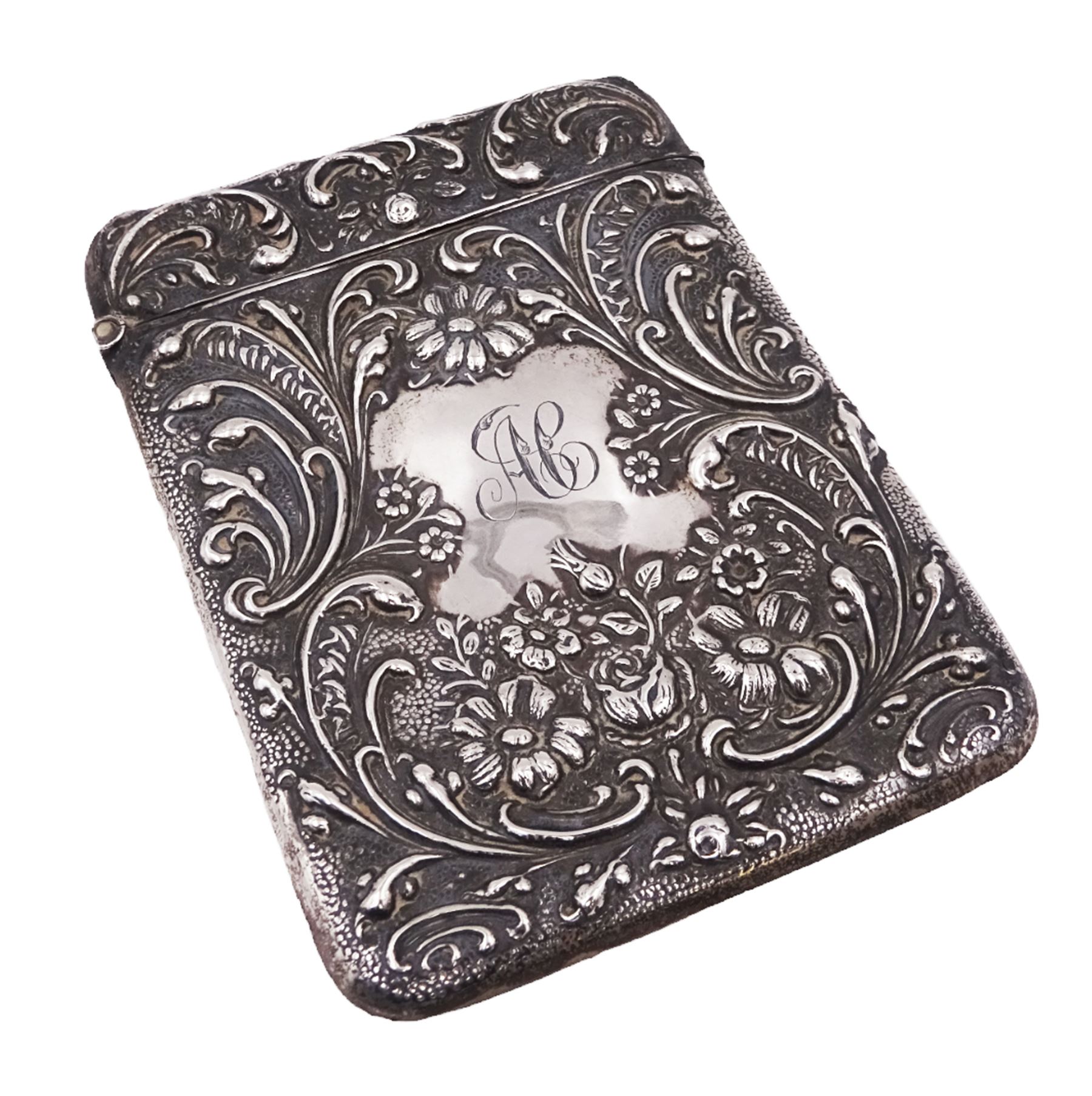 Edwardian silver card case, of typical rectangular form, with embossed floral and scrolling decoration throughout, engraved with monogrammed initials to front cover, hallmarked Cornelius Desormeaux Saunders & James Francis Hollings (Frank) Shepherd, Chester 1903, H9.7cm