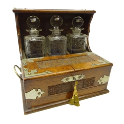  Edwardian oak three bottle tantalus with silver-plated mounts, carved floral panels, twin lidded front enclosing a four sectioned compartment above a secret drawer containing cribbage board, H32.5 x W36cm x D26.5cm   