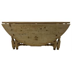 Traditional stripped pine dining table, circular drop-leaf top over double gate-leg action base with turned supports united by turned stretchers