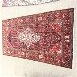Hamadan red ground rug, repeating border, central medallion, 325cm x 170cm