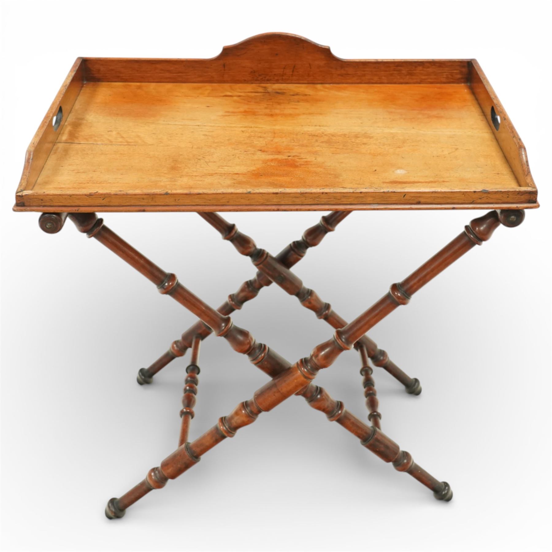 19th century coaching table, the rectangular tray top with shaped gallery and cut out carrying handles, raised on a folding X frame stand with turned supports and stretcher rails