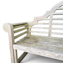 Lutyens design teak garden bench, shaped arched and slatted back over rolled arms and slatted seat, raised on square supports with box-stretcher