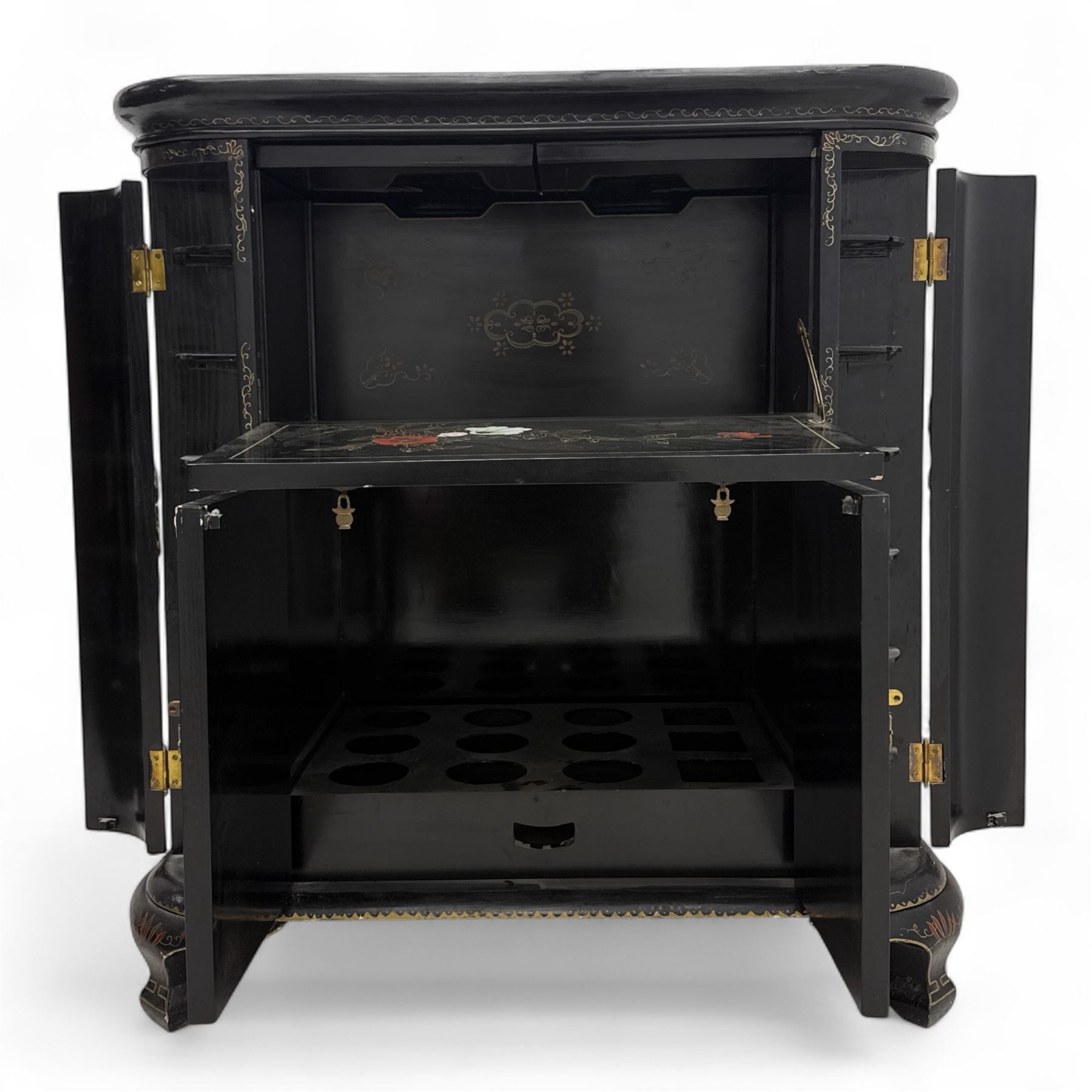 Early 20th century Chinoiserie lacquered cabinet, rounded rectangular top above a fall front enclosing fitted interior with lacquered decoration, over a pair of cupboard doors and flanked by side compartments with tiered bottle shelves, the black lacquer ground decorated throughout with raised and painted floral sprays, on shaped bracket feet