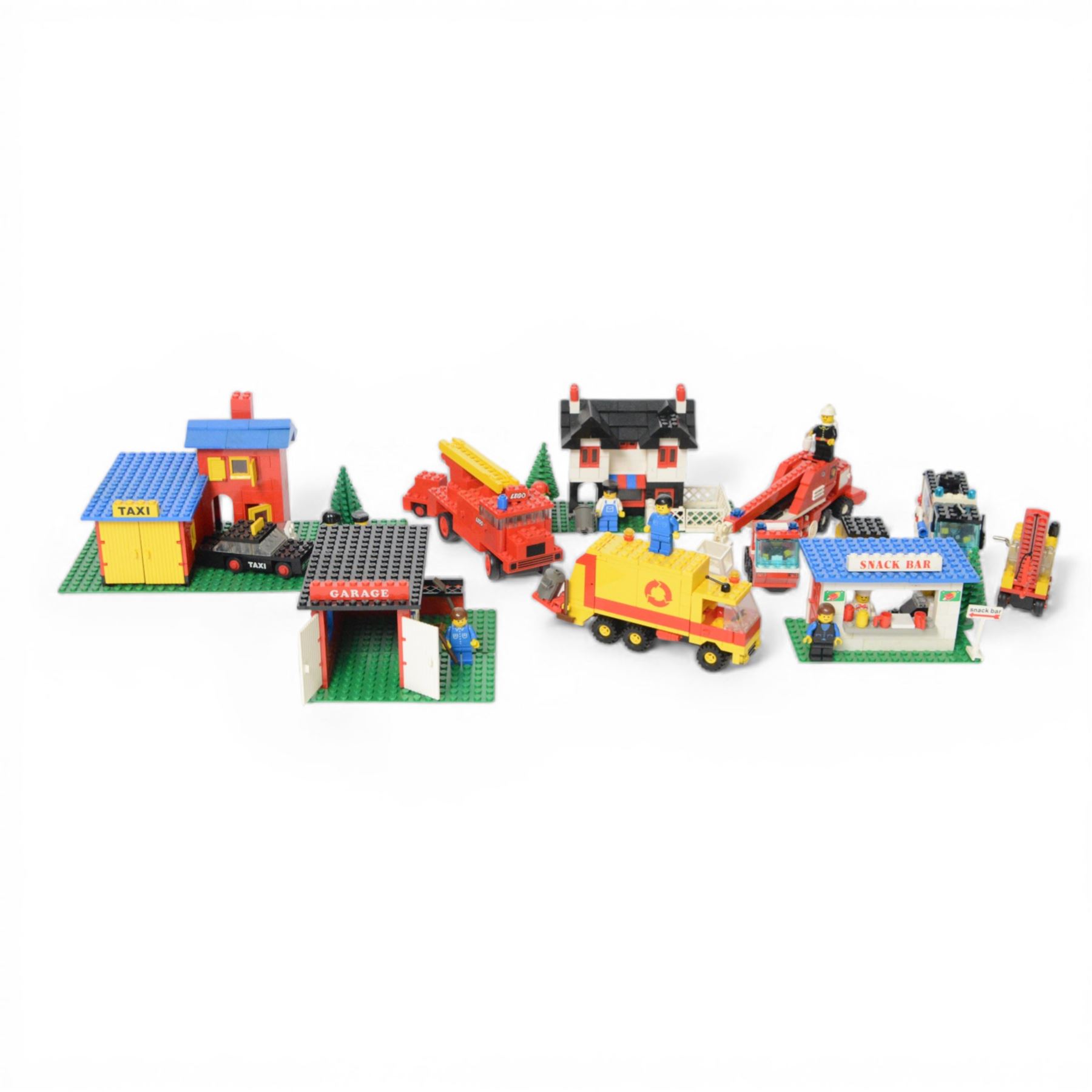 Nine vintage Lego Classic Town vehicles and buildings,  comprising no. 368-1 Taxi  Station, no. 675-1 Snack Bar, no. 374-2 Fire Engine, no. 643-2 Mobile Crane, no. 361-2 Garage, no. 00-2 Weetabix Promotional House, no. 6693 Recycle Truck, no. 6450-1 Mobile Police Truck and no. 6358 Snorkel Squad, all built with minifigures