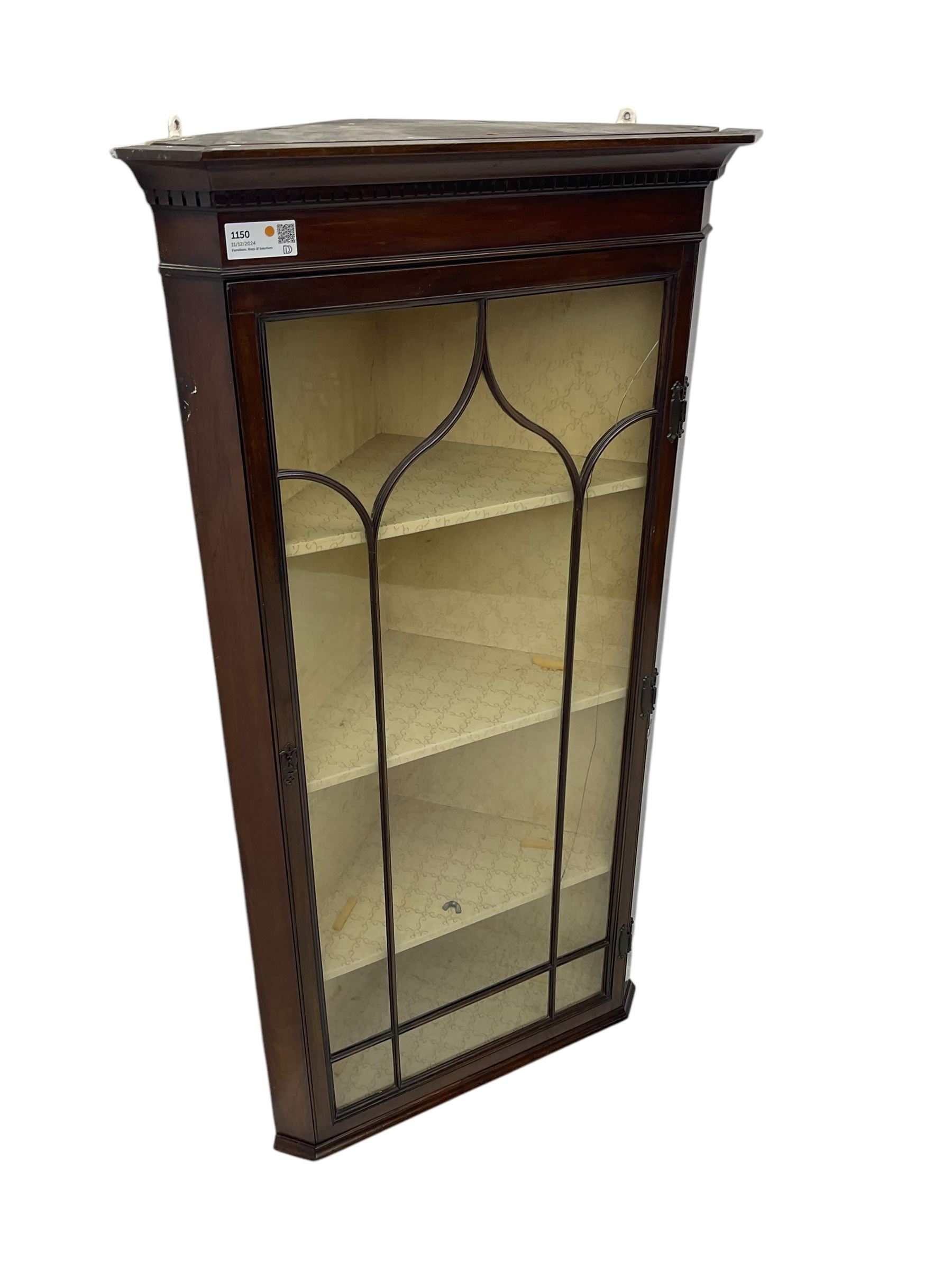 Early 20th century Georgian design mahogany wall-mounted corner display cabinet, projecting cornice with dentil frieze over astragal glazed door enclosing three fabric-lined shelves