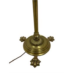 Edwardian brass plated copper standard lamp, telescopic stem on lobe moulded circular base with three projecting paw feet, with cream shade