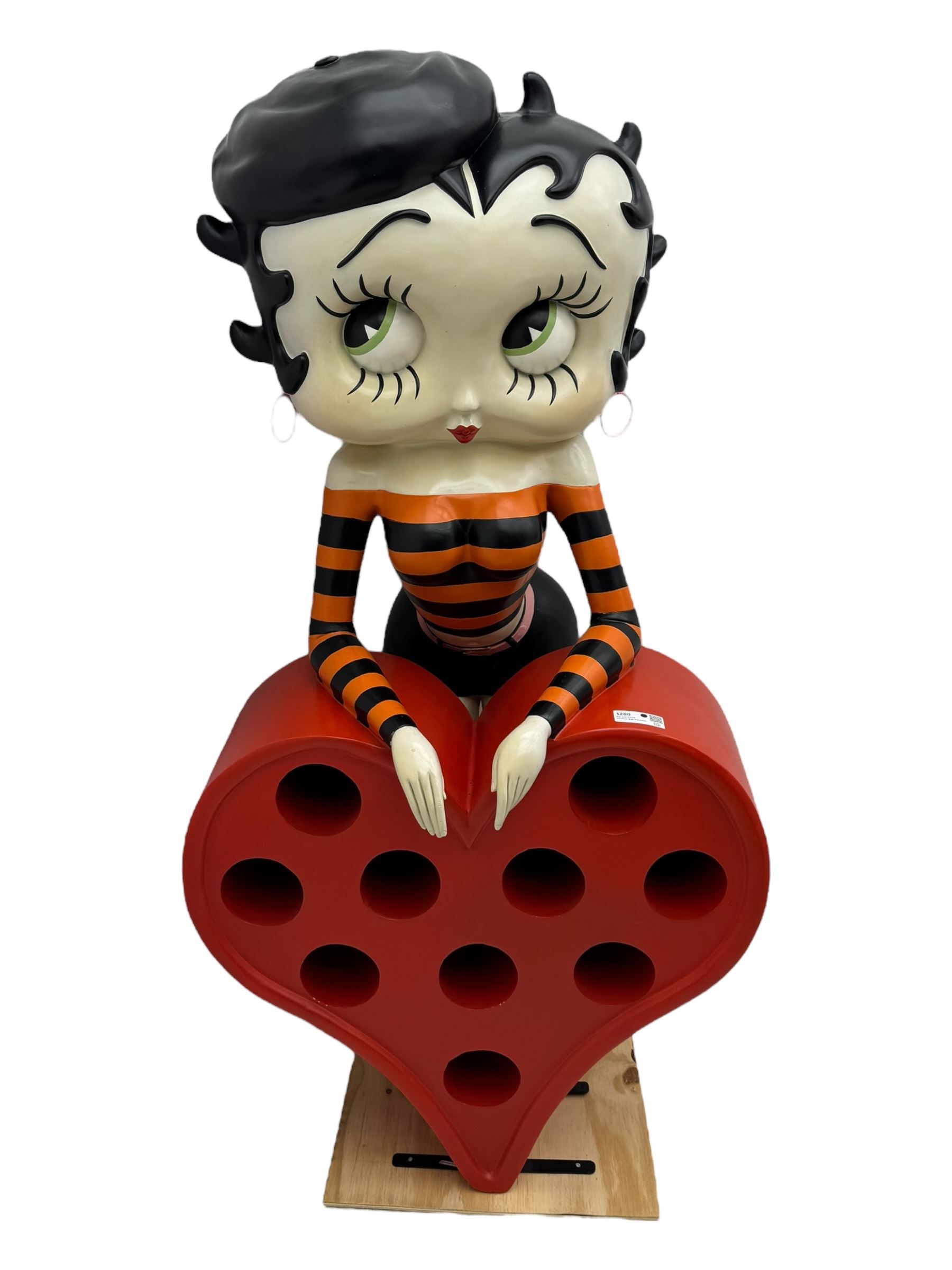 Contemporary large-scale Betty Boop painted wine rack, modelled leaning against a heart-shaped stand with ten circular bottle slots, dressed in black and orange striped attire