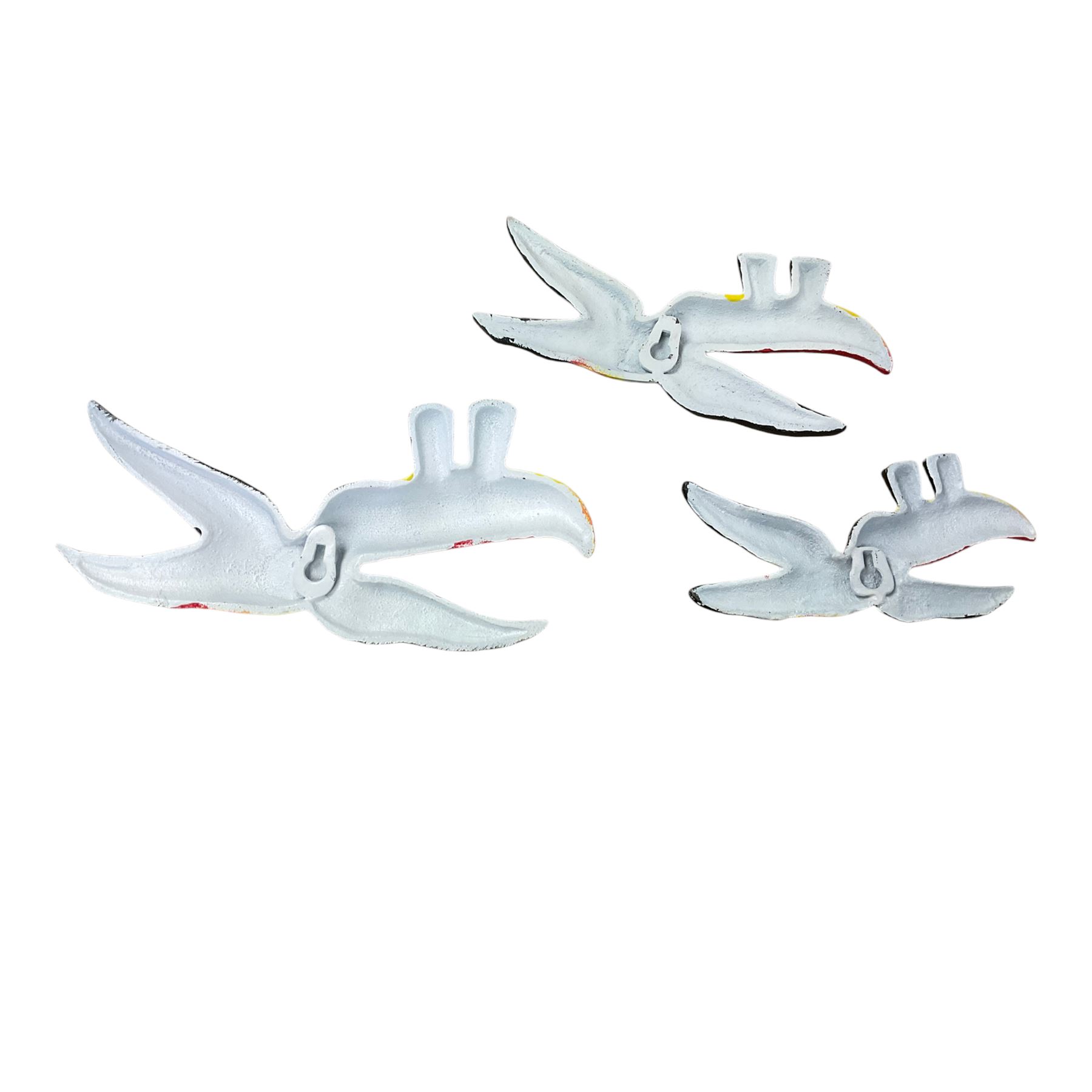 Three cast iron Guinness toucans in flight, together with two cast iron hooks