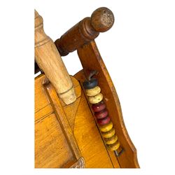 Late 19th century American oak child's metamorphic high chair and play table, carved spindle backrest with pierced splat, detachable tray with abacus and hand painted pastoral decoration, on turned supports with metal wheels