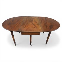 Early 20th century mahogany inlaid oval drop leaf dining table, the crossbanded and line inlaid top with twin hinged leaves (extends to 165cm), plain frieze centred by inlaid panel with stylised star motif, raised on four ring turned tapering supports terminating in brass caps and castors