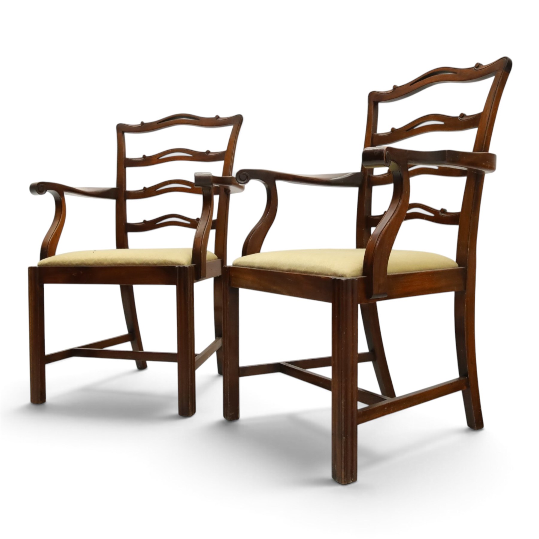 Pair of Georgian design Chippendale style mahogany elbow chairs, the pierced and waived ribbon ladder-back over scrolled arm terminals and yellow drop-in seats, on moulded and chamfered square supports