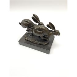 A bronze figure group, modelled as two hares in chase, signed Nick and with foundry mark, upon a rectangular marble base, overall H11cm L13cm