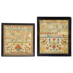 Two mid 19th century samplers, worked by two sisters, the first example by Rosina Grainger, age 12, the second by Selina Grainger, age 9, each depicting urns of flowers flanked by birds, beneath alphabets, within strawberry vine borders, in ebonised frames, largest example overall H40.5cm W35cm