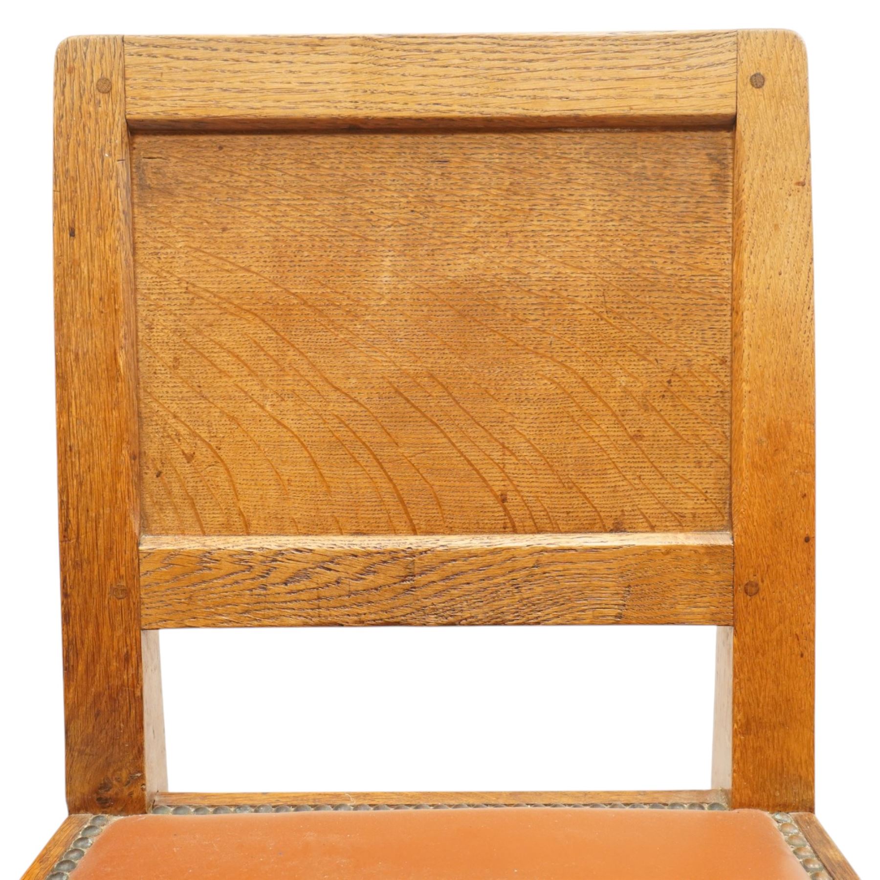 Mouseman - pair of 1940's adzed and panelled oak chairs, the rectangular adzed back-panel over seats upholstered in orange-tan leather with studwork, raised on turned octagonal supports united by box stretcher, with carved mouse signature, by the workshop of Robert Thompson of Kilburn
Provenance: purchased directly from the Kilburn workshop in the late 1940s